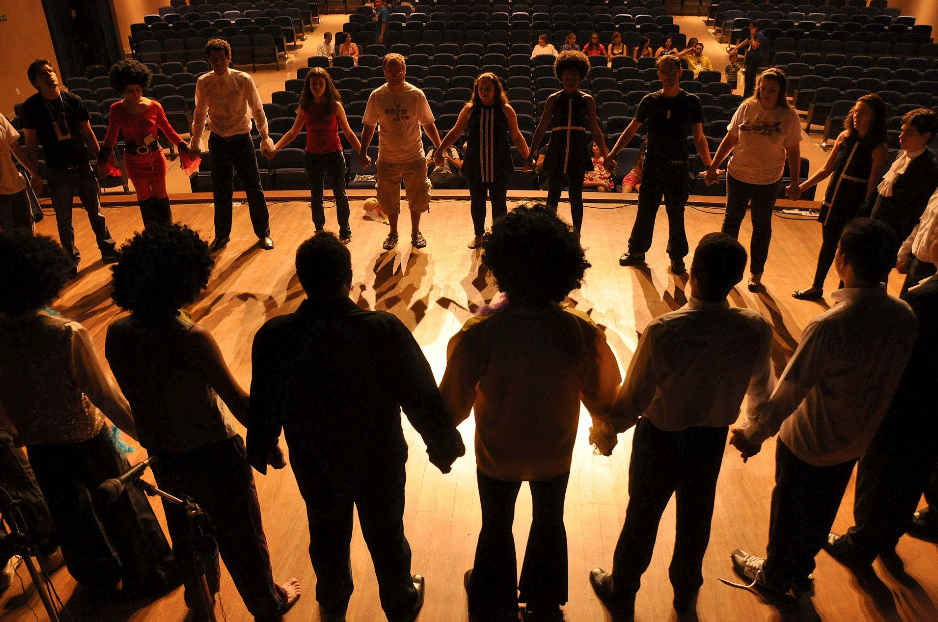 people holding hands at stage